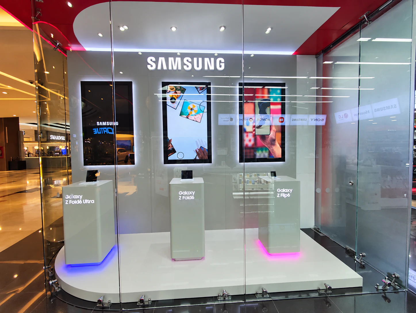 Exhibición Samsung con tres pantallas digitales y productos dentro de una tienda