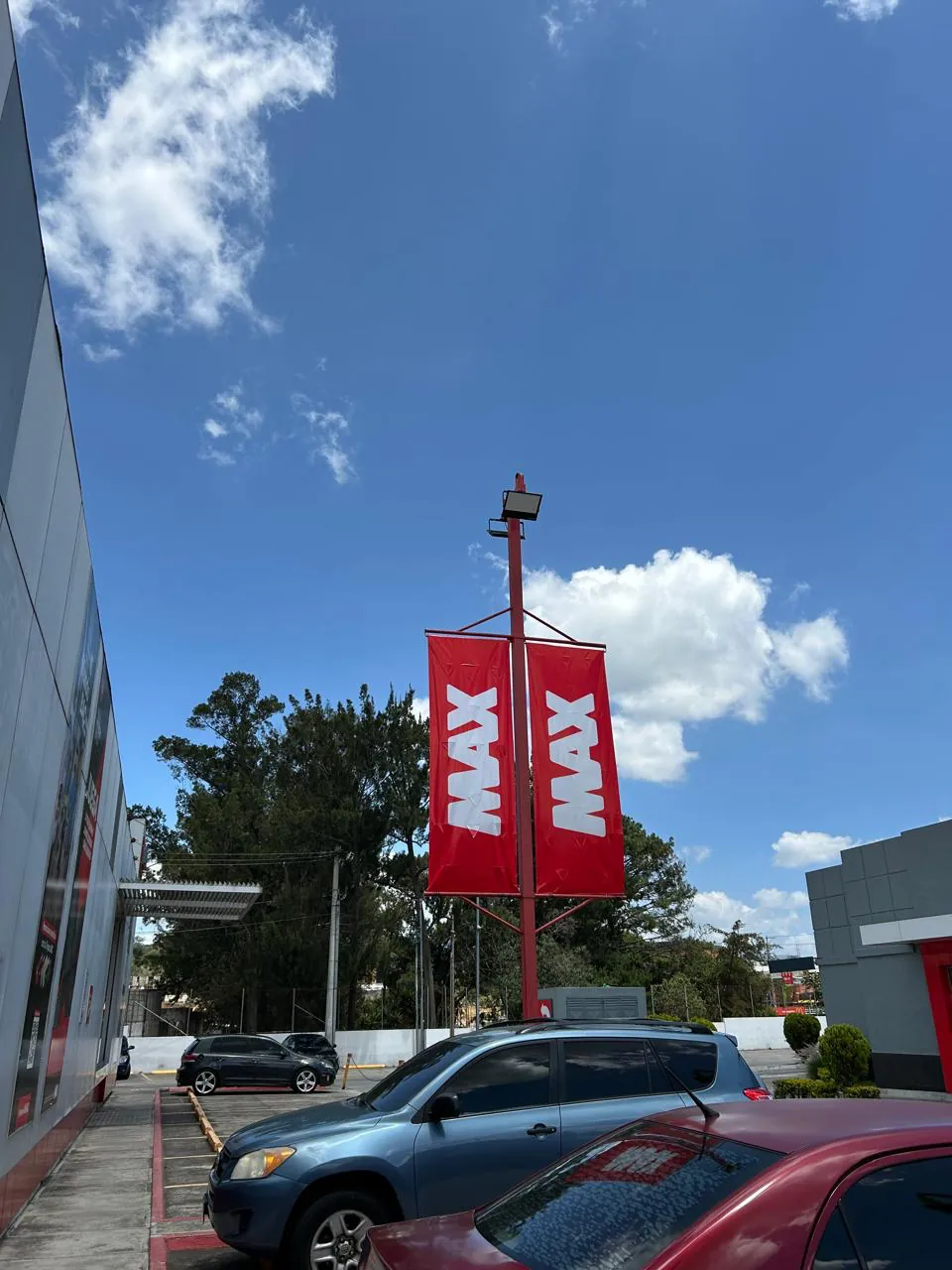Banderolas MAX en poste rojo en el exterior de la tienda